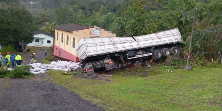 Caminhão carregado com açúcar tomba na BR-277 e quase atinge igreja